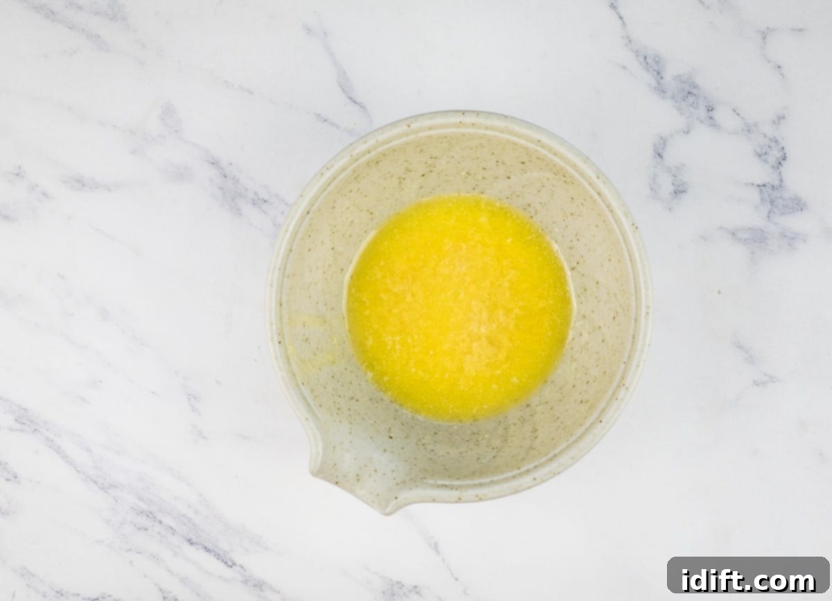 Fiery Crumb Carrot Bake 11 Melted butter combined with Dijon mustard, horseradish, shredded Parmesan cheese, and dried thyme in a mixing bowl.