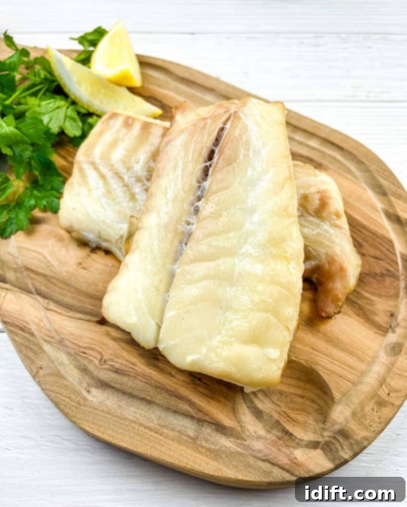 Smoked Cod on a cutting board with lemon and parsley.