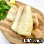 Smoked Cod on a cutting board with lemon and parsley.