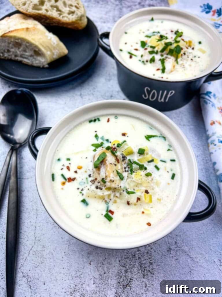Two black bowls of Cullen Skink with crusty bread in the background, steam gently rising.