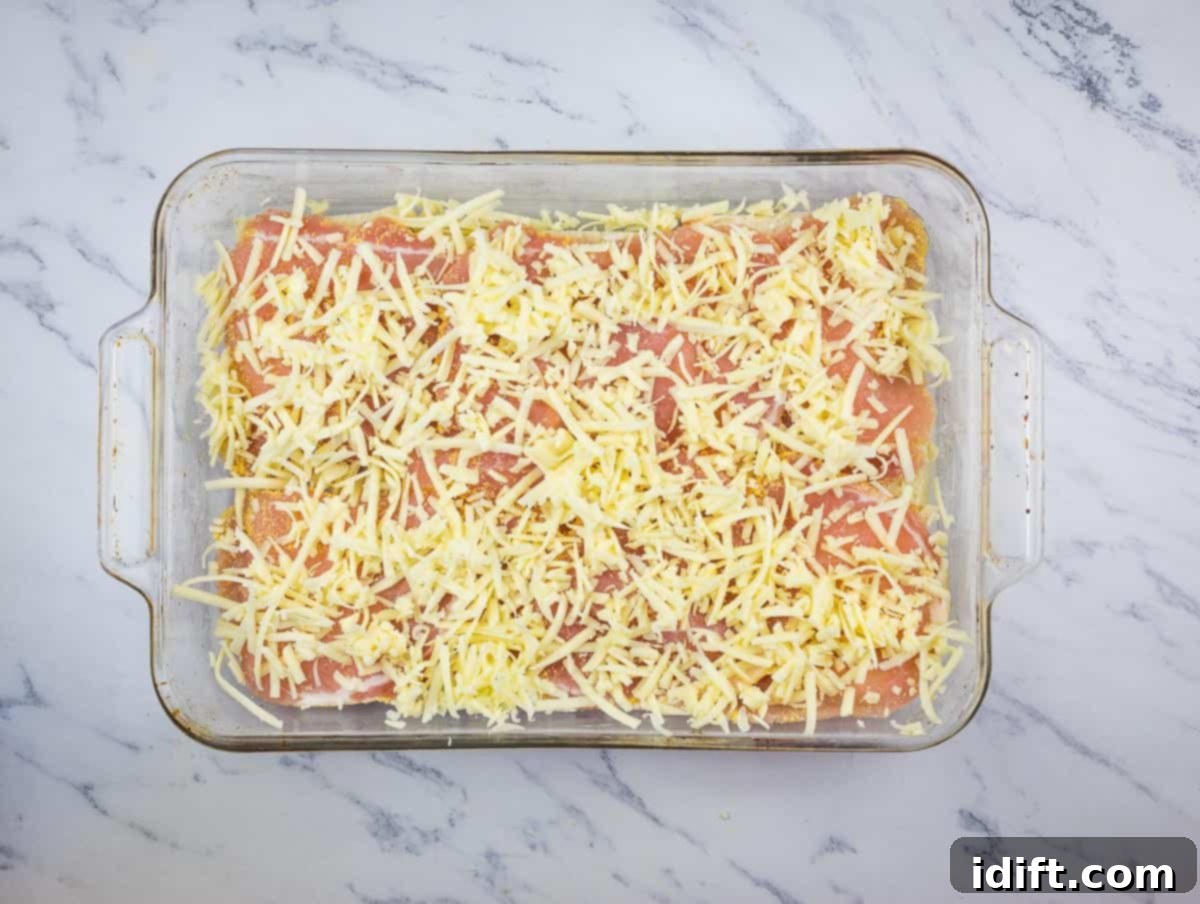 Sliced meat and shredded cheese added on top of the first layer of bread.
