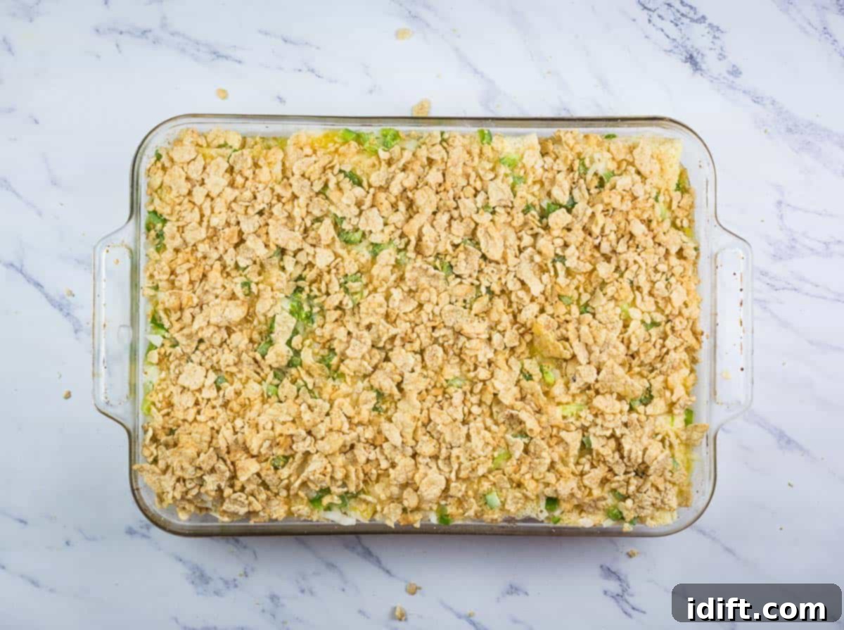 The soaked casserole topped with crushed cereal crumbs and drizzled with melted butter, ready for the oven.
