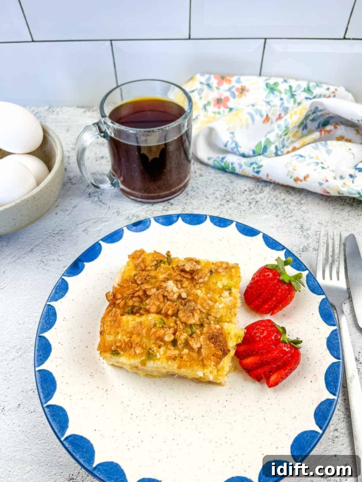 A golden-brown Christmas Morning Casserole, freshly baked and served with strawberries.
