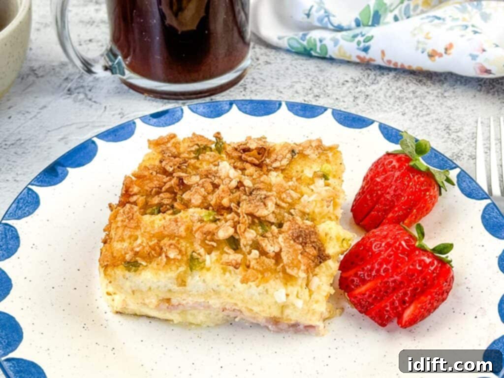 A closeup of a single serving of Christmas Morning Casserole on a white plate, showing the layers.