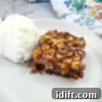 40 Delightful Christmas Desserts Your Family Will Adore 14 Turtle Brownie on a plate with a scoop of vanilla ice cream.