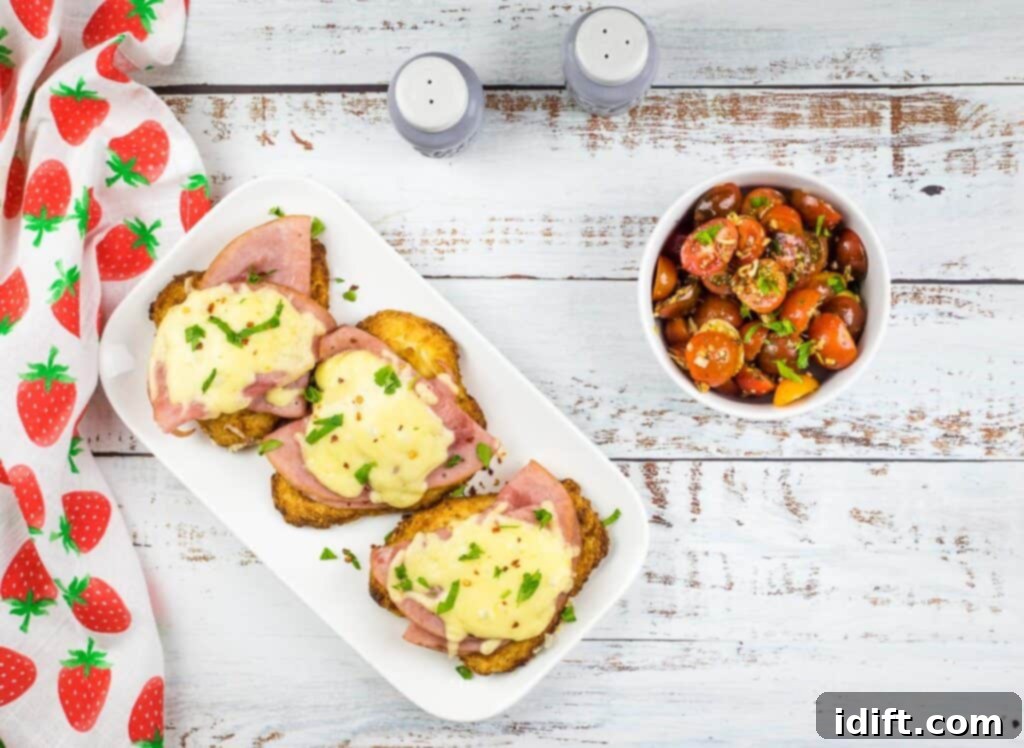 A top down shot of air fryer chicken cordon bleu with a vibrant tomato salad in a bowl nearby, suggesting a complete meal.