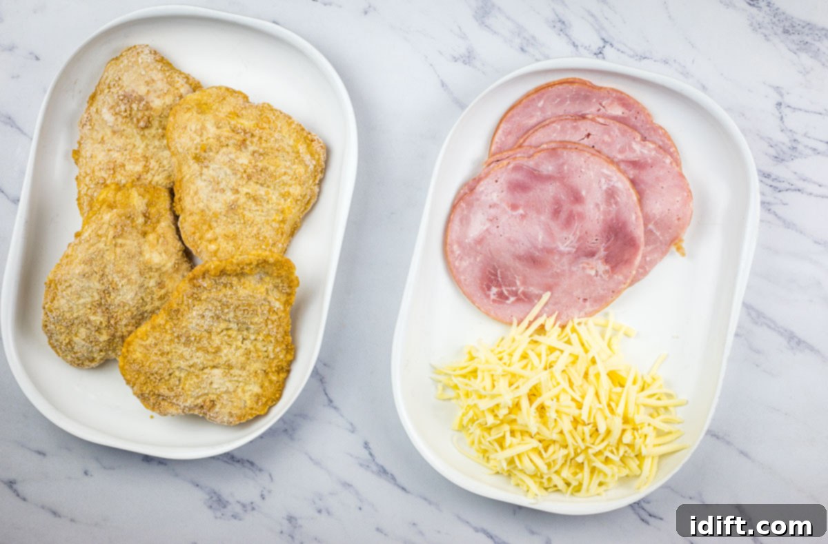 Ingredients laid out on a countertop, ready to make air fryer chicken cordon bleu, including frozen chicken patties, ham, and cheese.