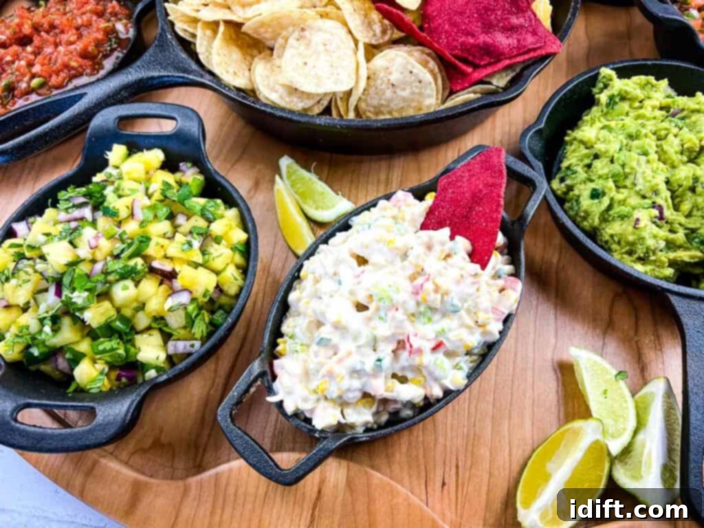 A vibrant cold corn dip elegantly arranged on a larger snack board alongside fresh guacamole, an assortment of chips, and other delightful accompaniments.