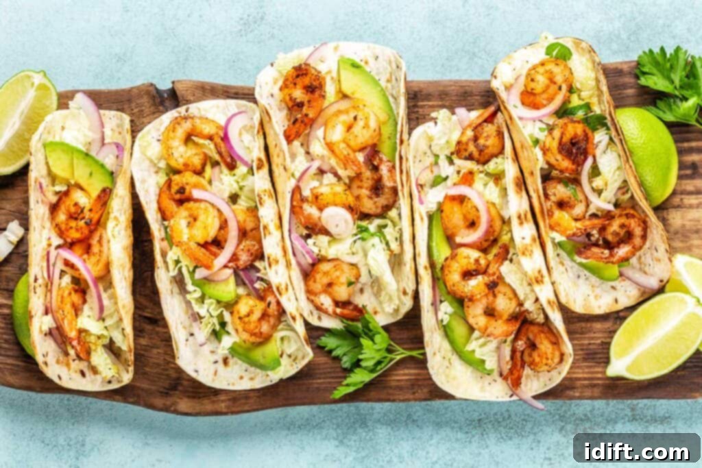 Next-Level Taco Bar Ideas for Your Tuesday Feast 3 A top-down shot of vibrant shrimp tacos, garnished with fresh cilantro, avocado, and lime, ready to be enjoyed.
