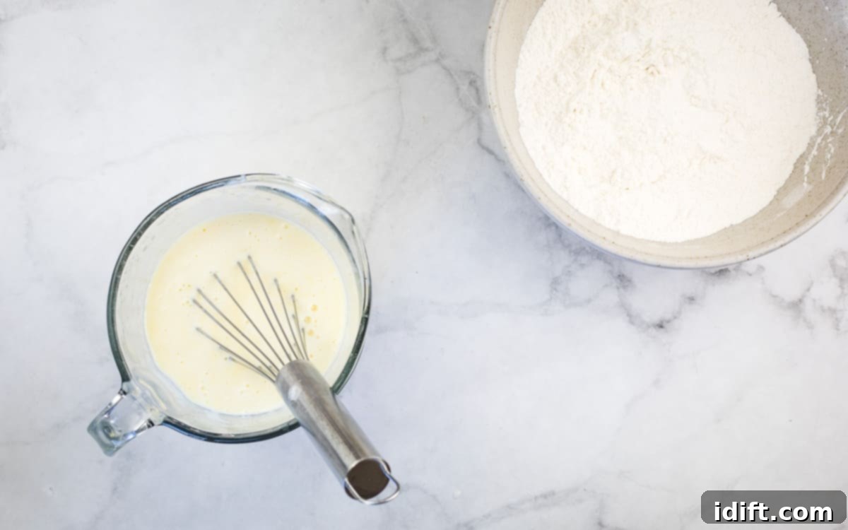 Wet ingredients for pancakes, including buttermilk, eggs, melted butter, and vanilla extract, thoroughly mixed in a separate bowl.