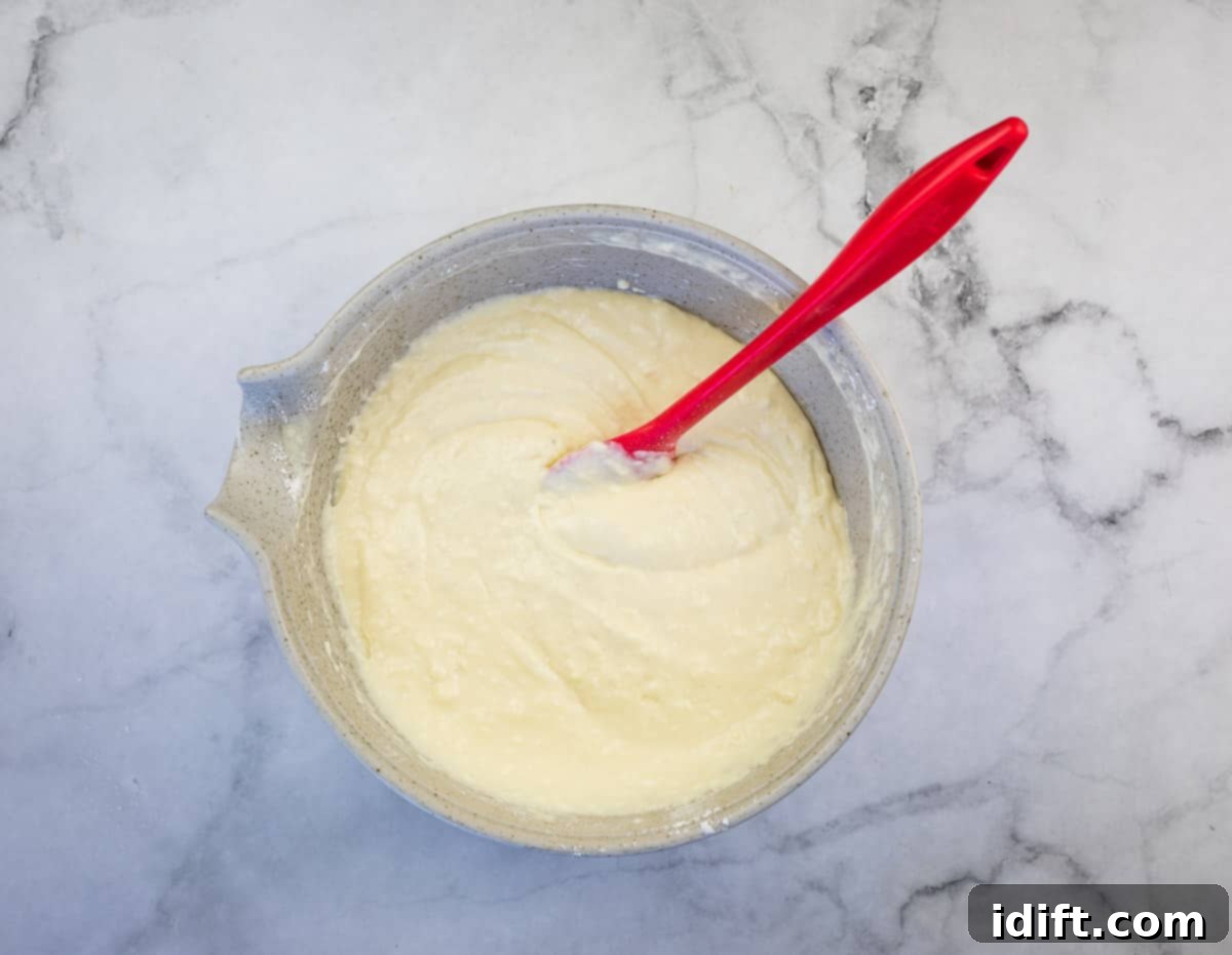 Pancake batter, showing wet and dry ingredients gently mixed until just combined, with a few lumps still visible.
