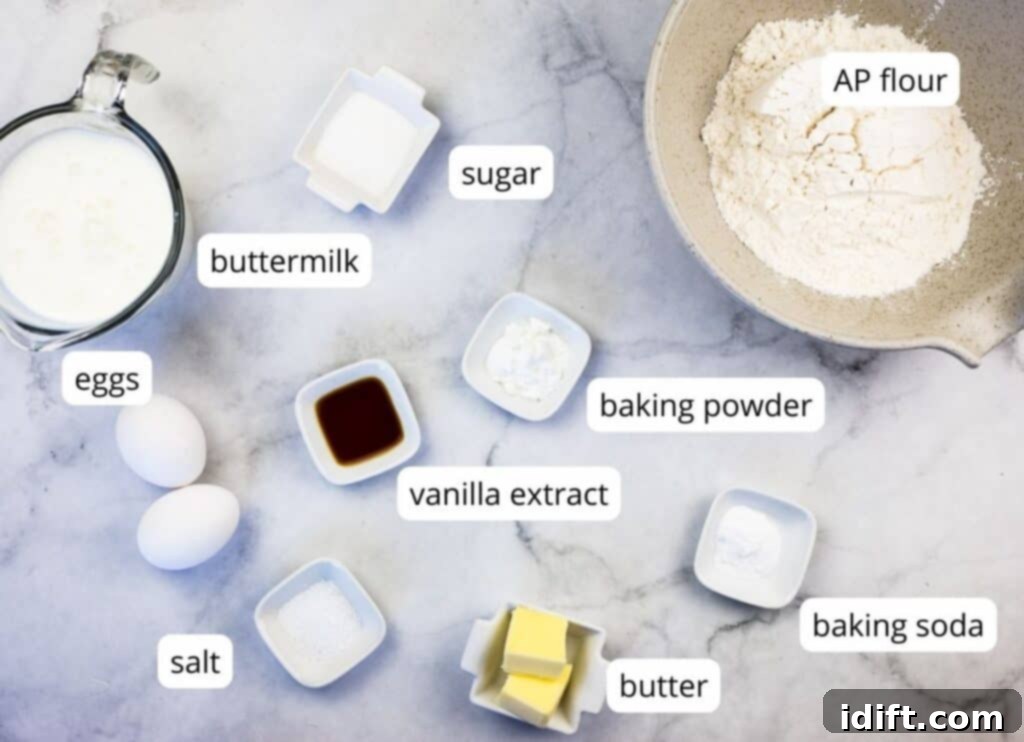 A top-down image displaying neatly labeled ingredients for buttermilk pancakes, including flour, sugar, baking powder, baking soda, salt, buttermilk, eggs, melted butter, and vanilla extract.