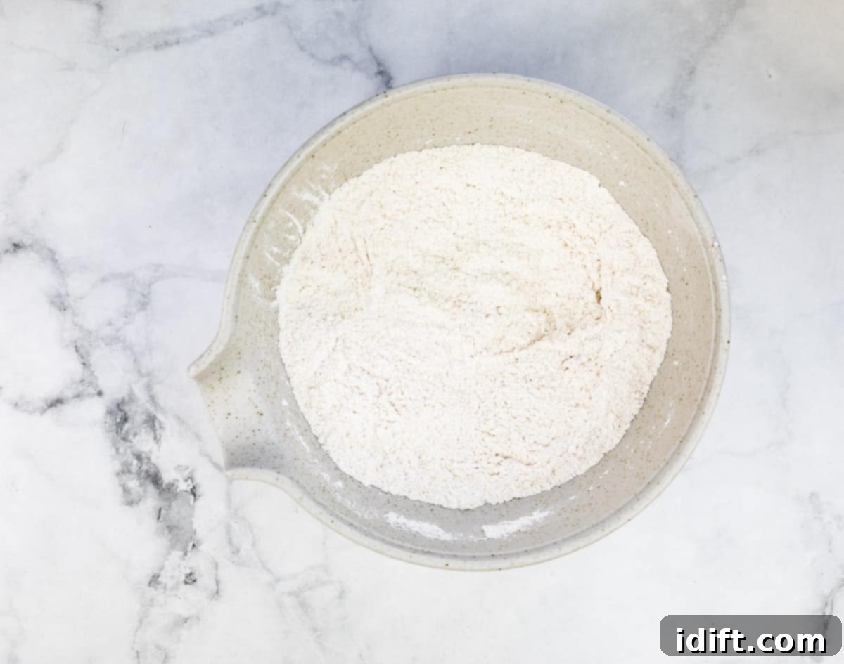 Dry ingredients mixed together in a bowl, showing the flour, sugar, baking powder, and spices combined.