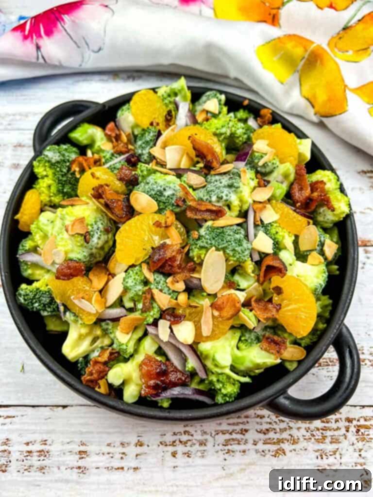 Vibrant Broccoli Salad with Zesty Orange and Smoky Bacon Crunch 2 A vibrant Broccoli Salad with Bacon and Almonds, beautifully presented in a black serving dish, ready to be enjoyed.