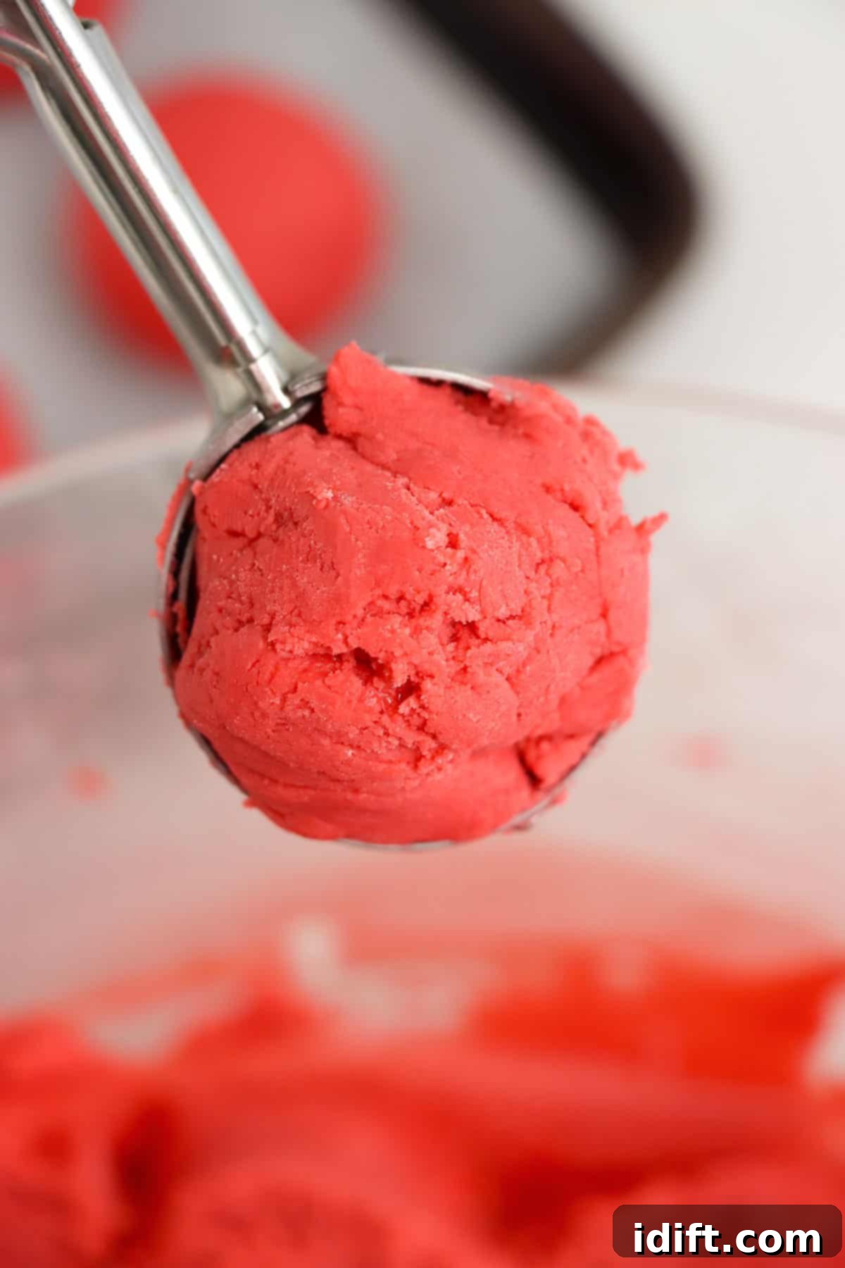 A cookie scoop filled with the red velvet truffle mixture, ready to be shaped.