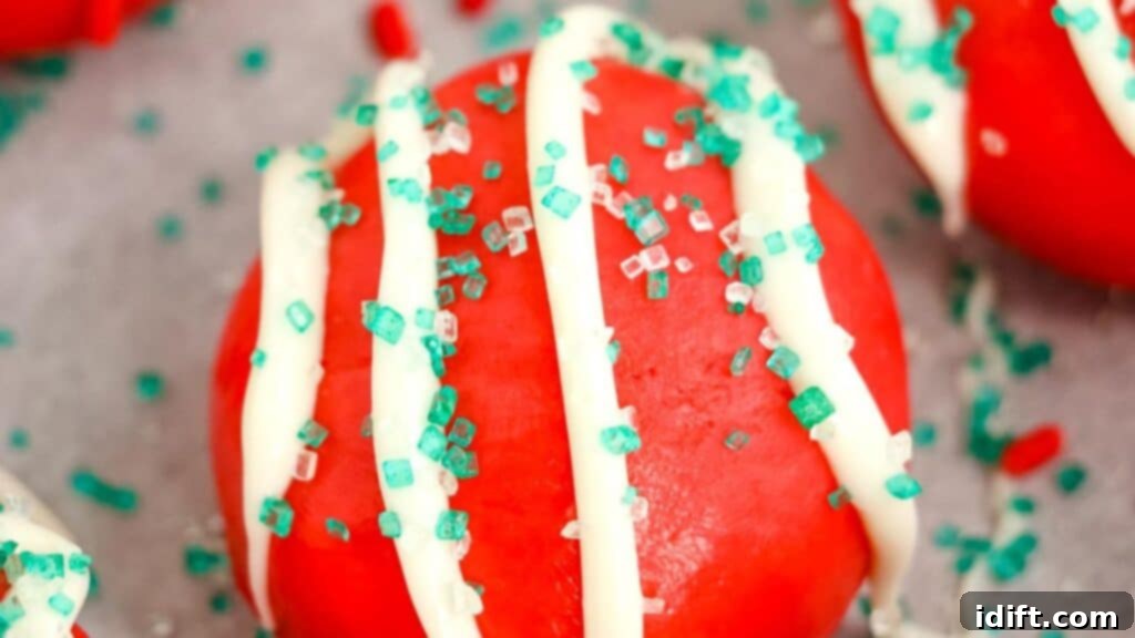 A charming plate of vibrant red velvet truffles, beautifully covered in a festive assortment of sprinkles, ready to be enjoyed.