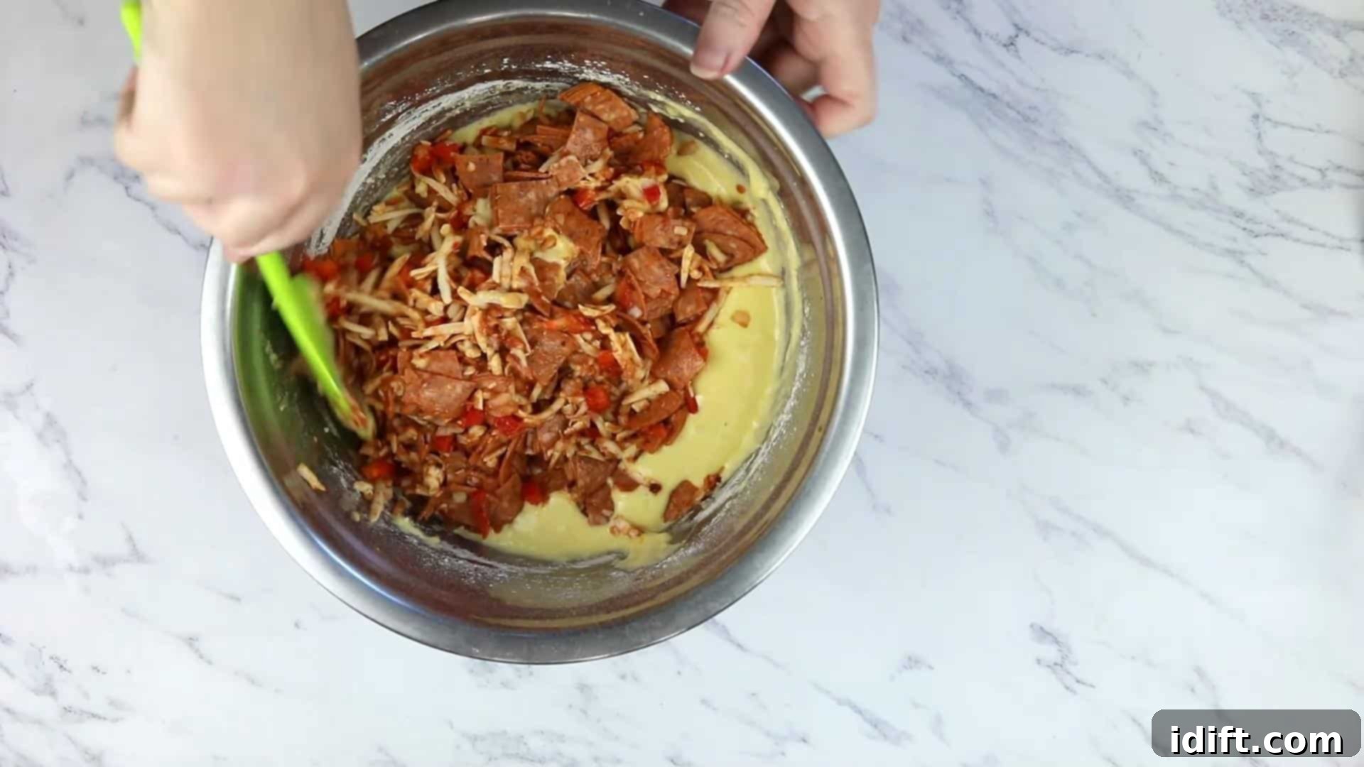 Savory Pizza Cups 9 The pizza ingredients and muffin batter being gently combined in a large bowl.