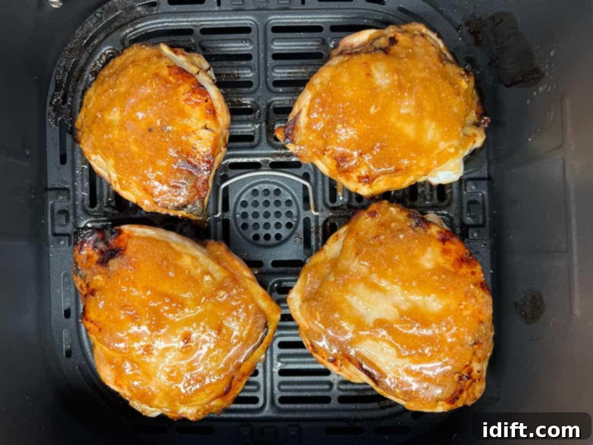 Skin side up chicken in the air fryer basket.