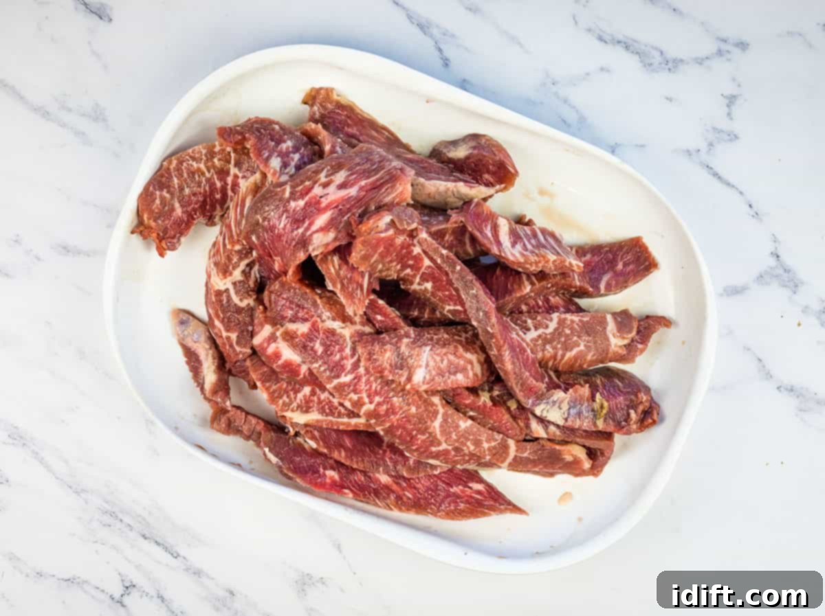 Sizzling Steak Skewers with Zesty Mojo Rojo 6 Chef skillfully thinly slicing a piece of sirloin steak against the grain on a wooden cutting board.