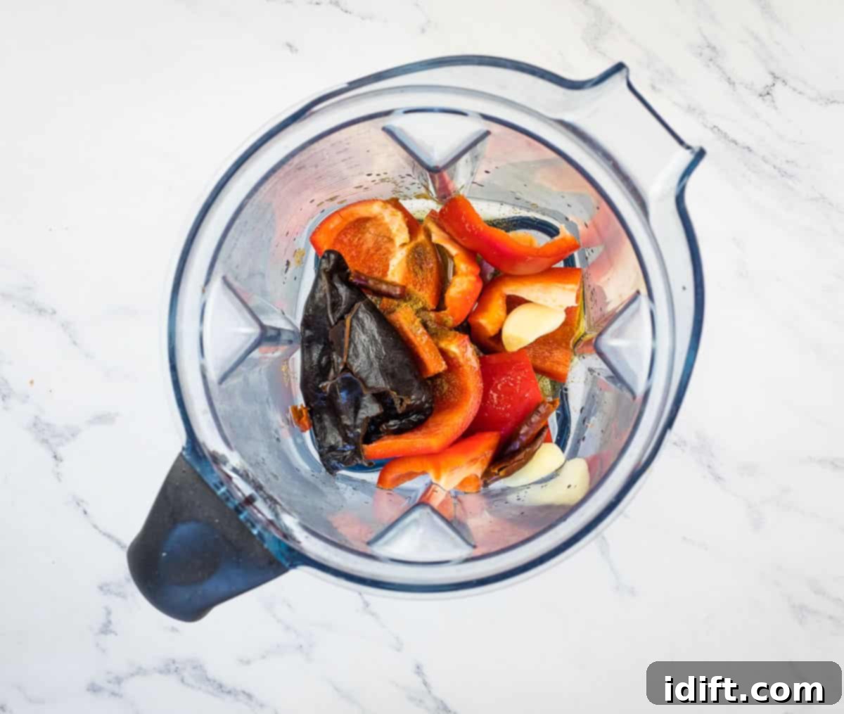 Sizzling Steak Skewers with Zesty Mojo Rojo 7 Rehydrated dried chiles, red bell pepper, fresh garlic, and other spices placed inside a blender cup, ready for pureeing.
