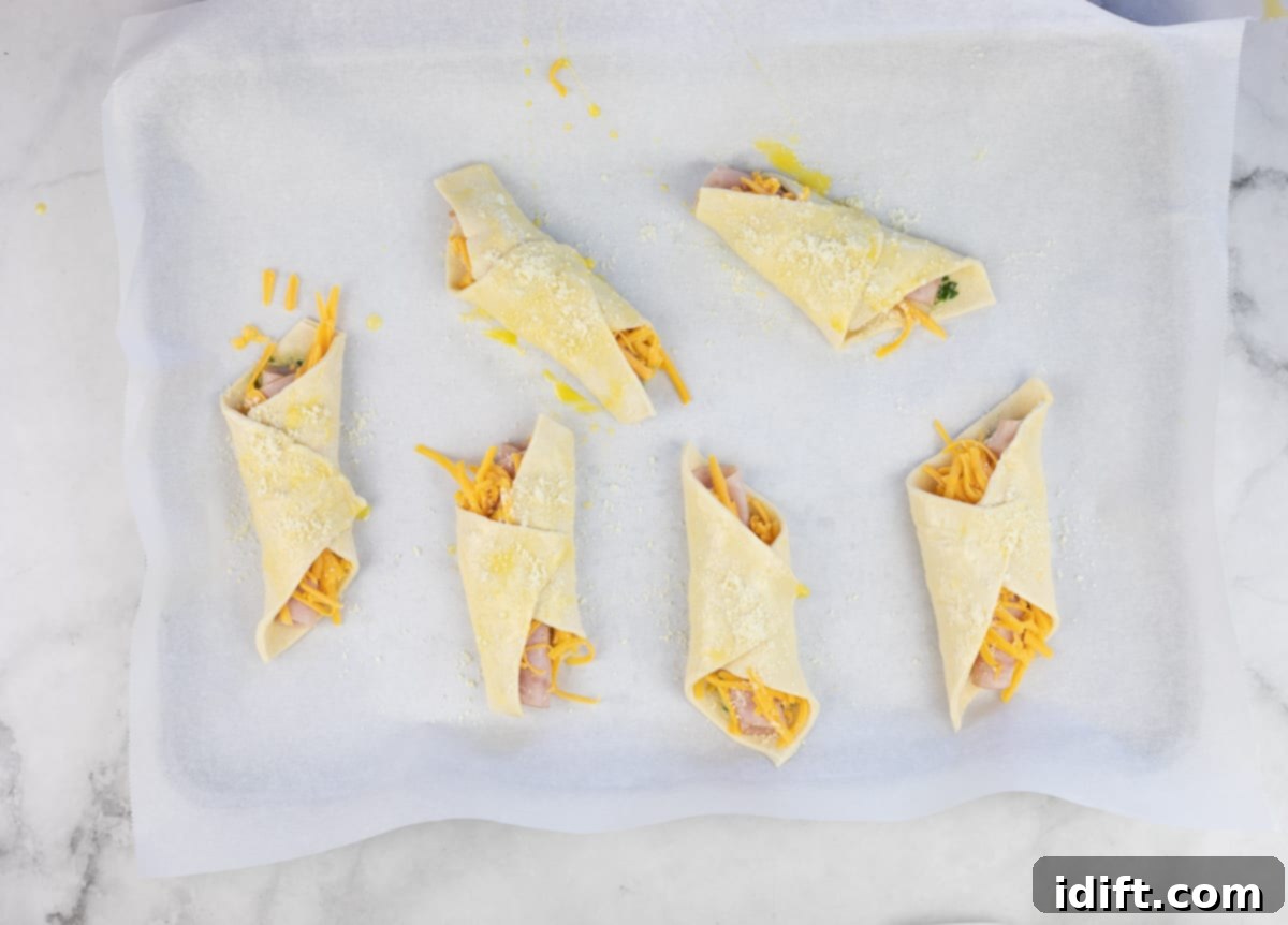 Folded turnovers, brushed with egg wash, arranged on a baking sheet, ready for the oven.