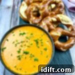 Hearty Guinness Beer Cheese Dip 10 Guinness Cheese Dip in a black bowl with pretzels nearby.