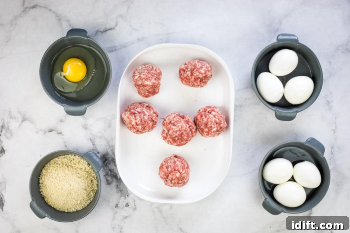 Crispy Baked Scotch Eggs 7 Sausage divided and rolled into balls on a plate.