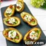 Fully loaded Baked Potato Skins on a black platter.