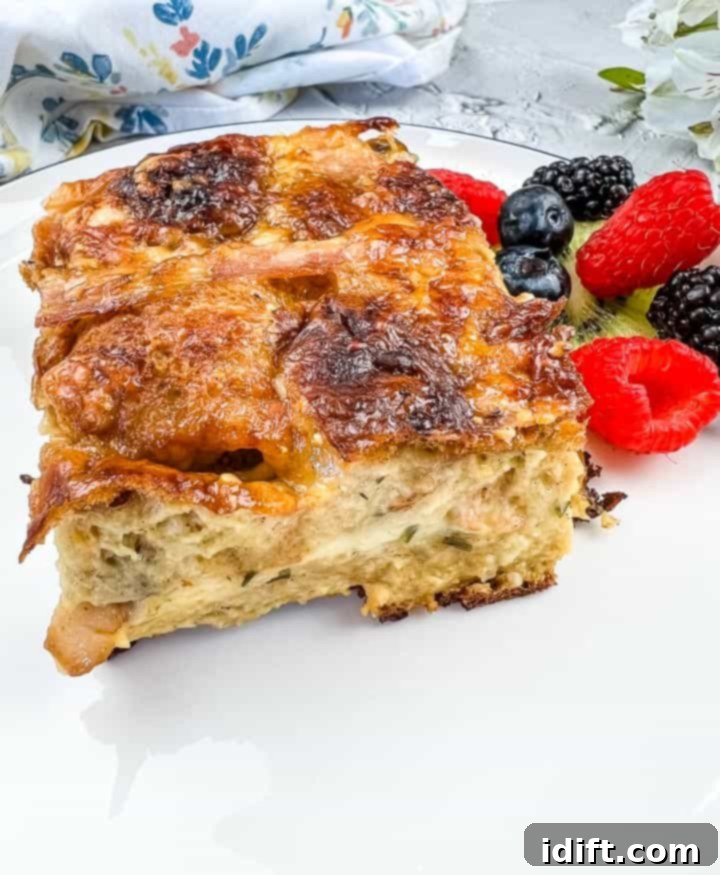 Spiced Hot Cross Bun French Toast Bake 12 Hot Cross Bun Breakfast Casserole on a white plate with berries.