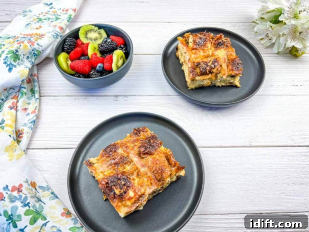 Spiced Hot Cross Bun French Toast Bake 5 A horizontal image of 2 servings of hot cross bun brunch casserole on black plates.