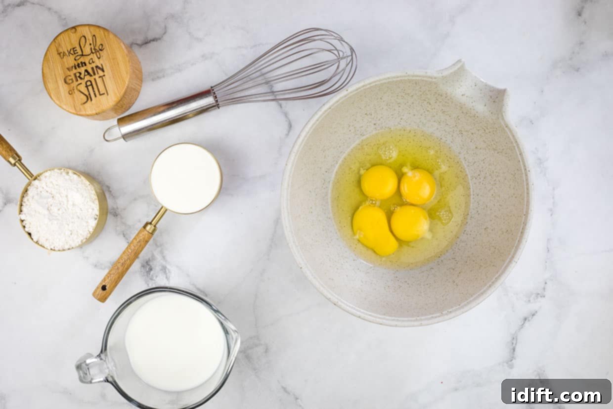 Eggs in a bowl next to a whisk and other ingredients.