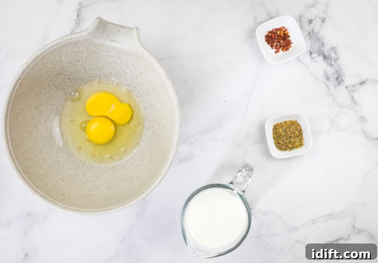 Chicken Florentine Artichoke Casserole 7 Cracked eggs in a bowl next to milk and spices.