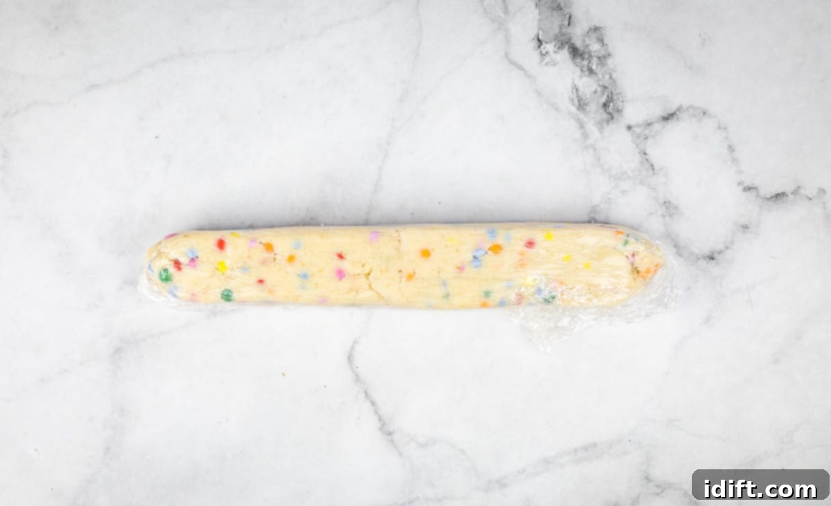 Spring Blossom Shortbread with Cheerful Candy Drops 10 A shortbread dough log wrapped tightly in plastic, chilling.