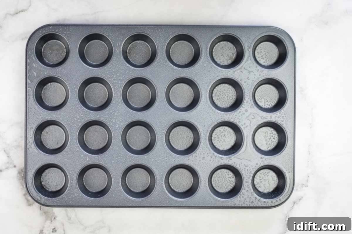 Sausage Pancake Poppers 11 A mini muffin tin generously sprayed with nonstick cooking spray, ready for filling.