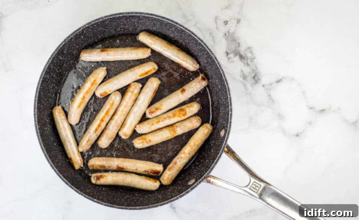 Sausage Pancake Poppers 7 Browned sausage cooking in a skillet on the stovetop.