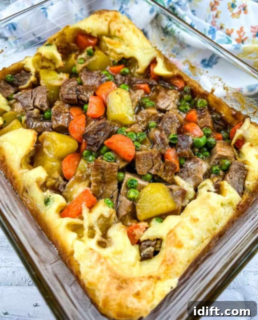 A hearty Leftover Roast Beef Yorkshire Pie, perfectly baked in a casserole dish, showcasing its crispy edges and rich filling.