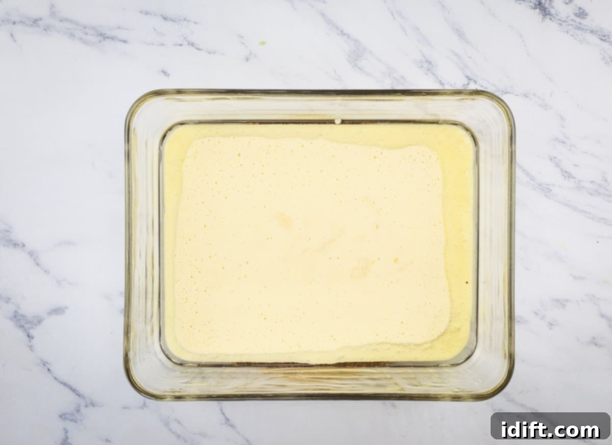 Hot oil shimmering in a baking dish, with the Yorkshire pudding batter just poured in, creating a perfect base.