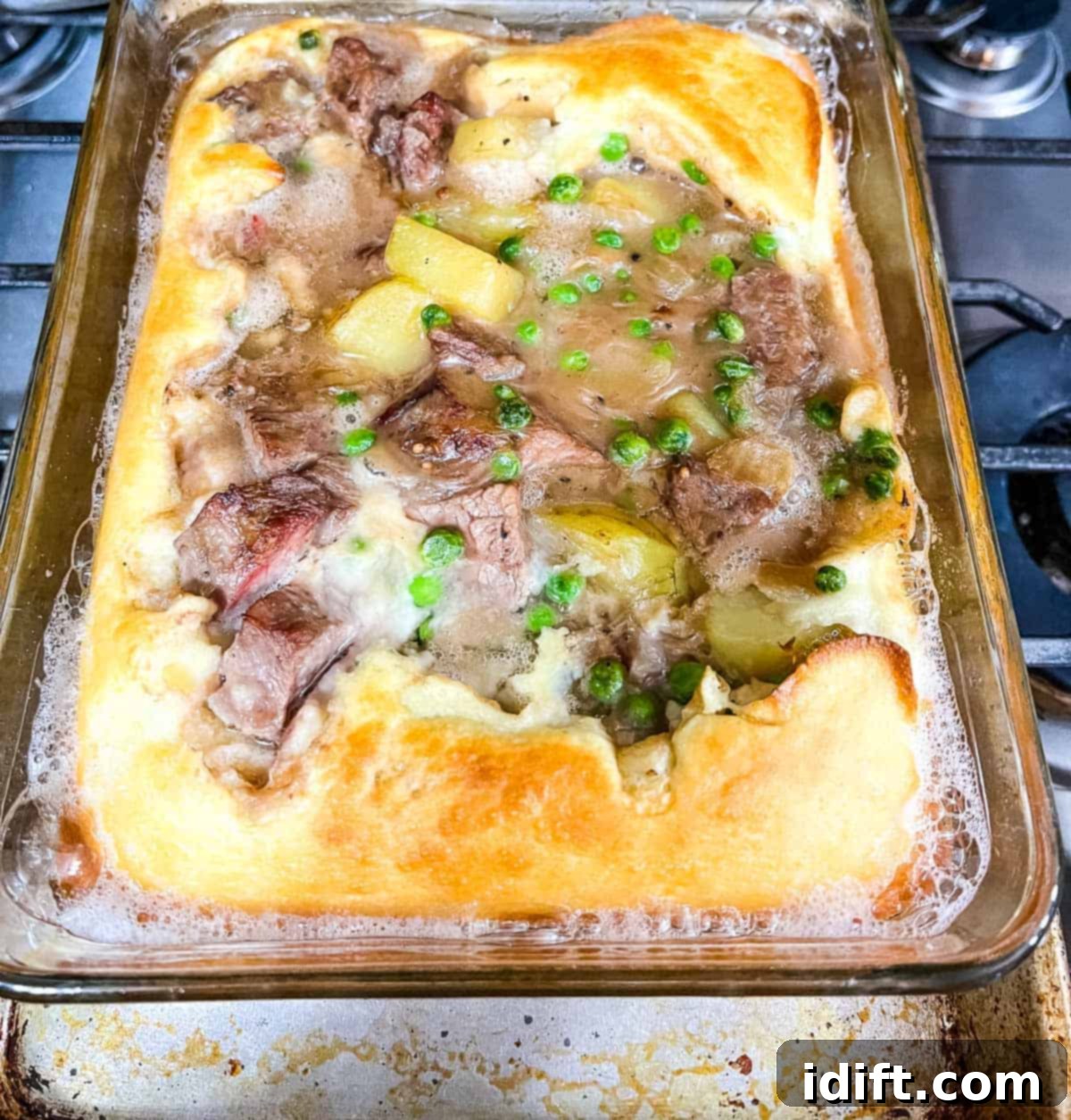 A freshly baked Yorkshire pudding pie, golden and puffed, just removed from the oven and ready to be served.