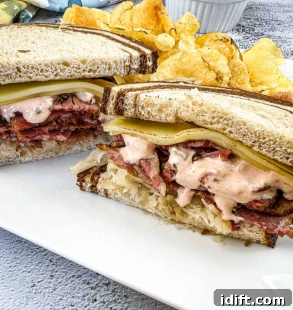 A cut Pastrami Reuben Sandwich on a plate with chips.
