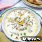Potato and Green Pea Chowder 12 Potato & Pea Chowder in a bowl with bread in the background.