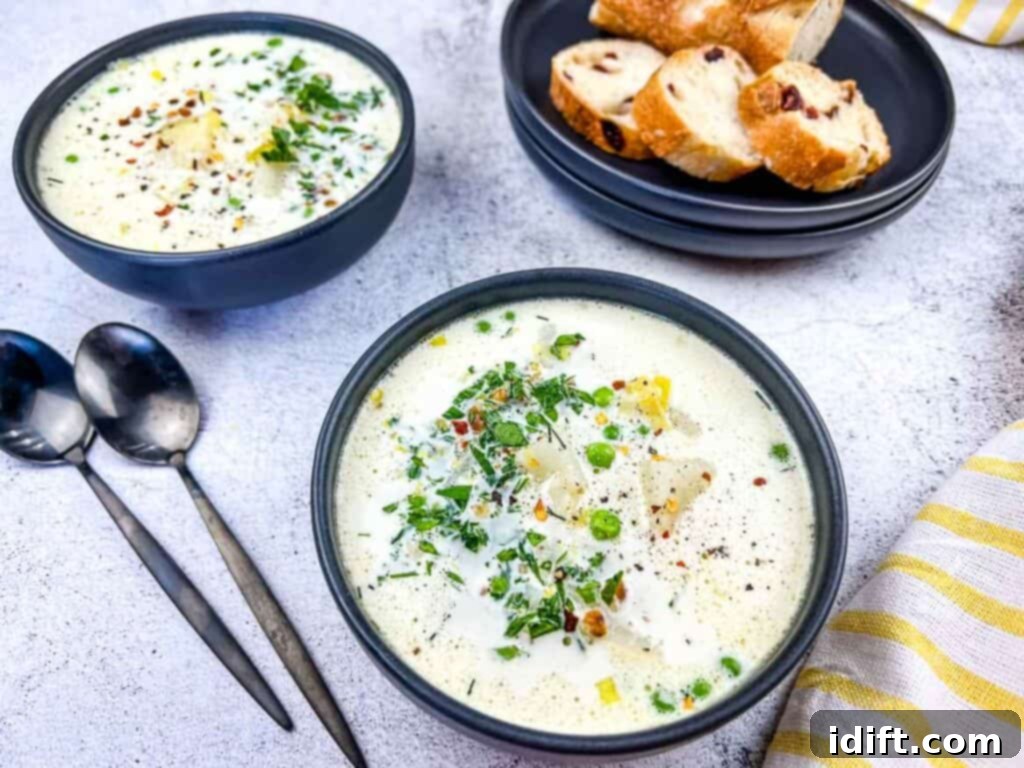 Potato and Green Pea Chowder 3 Two dark bowls filled with steaming Creamy Potato & Pea Chowder, served with slices of crusty bread.
