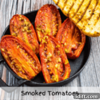 Smoked tomatoes on a black plate with grilled bread on the side, a rustic and flavorful appetizer.