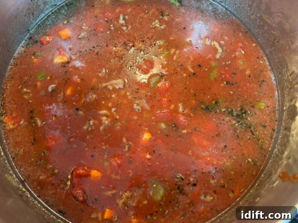 Liquid ingredients, beans, and bay leaves added to the pot, beginning to simmer.