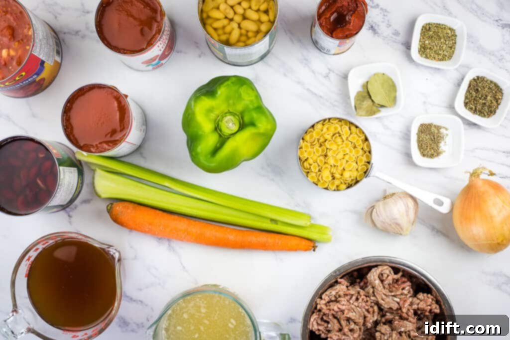 A selection of fresh and canned ingredients for Pasta e Fagioli Soup on a rustic wooden table.