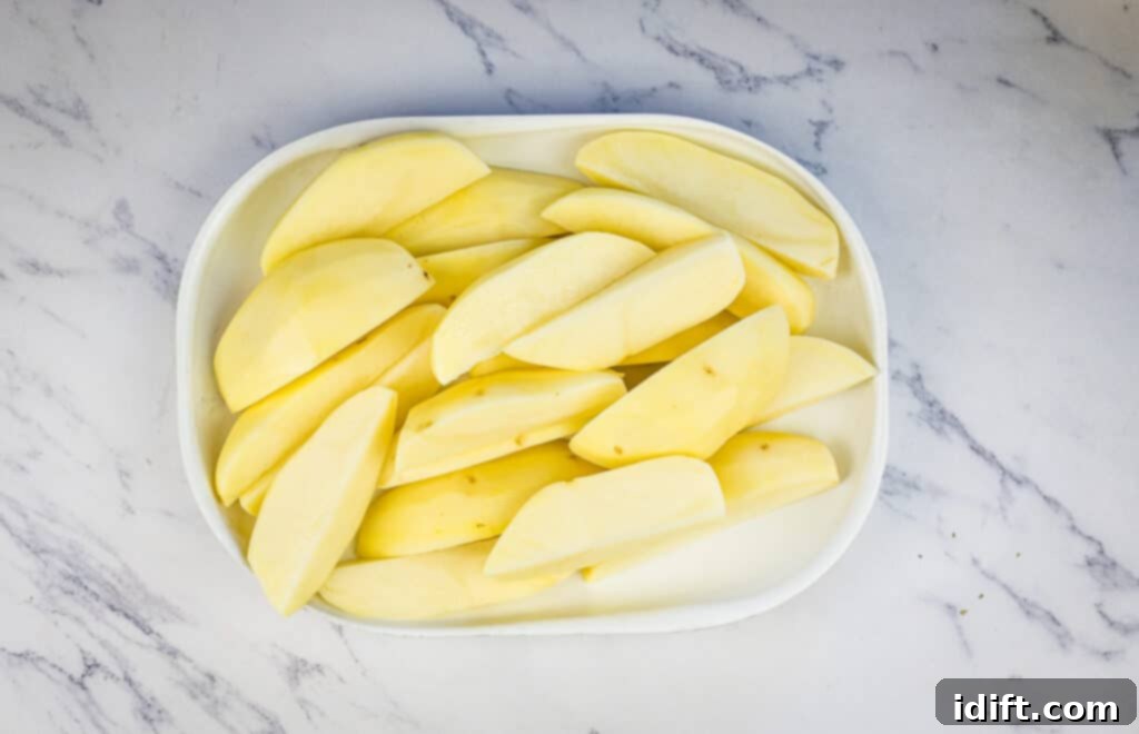 Potatoes cut into wedges on a plate.