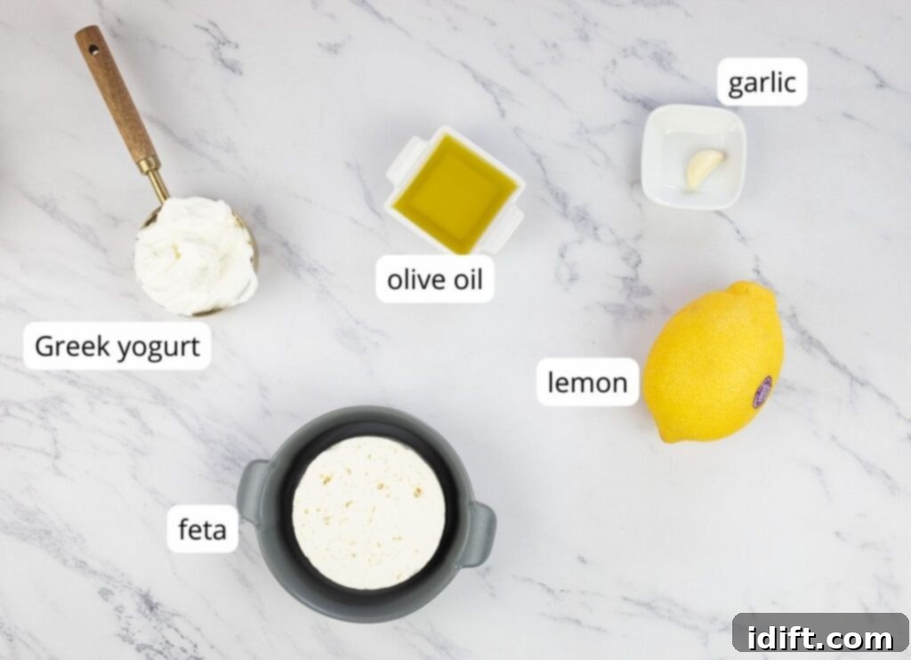 Labeled ingredients for making whipped feta, including feta cheese, Greek yogurt, olive oil, garlic, and lemon zest.
