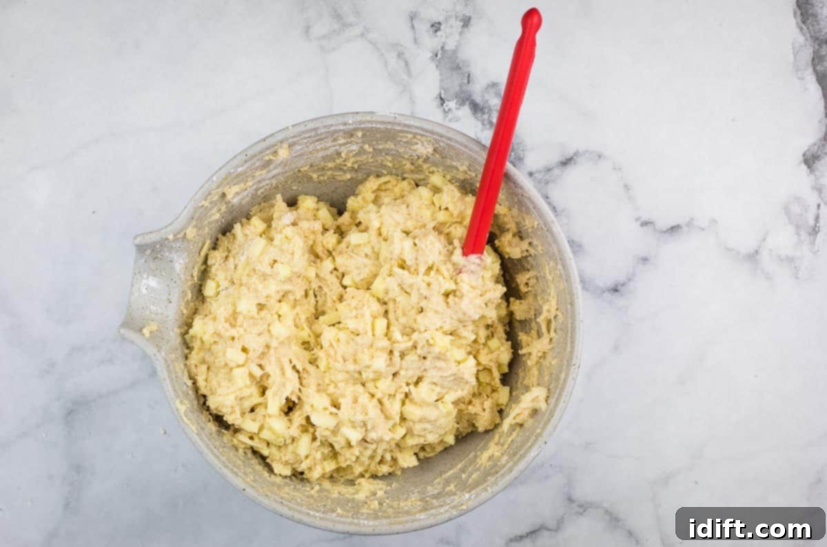 The combined muffin batter, showing a few lumps, indicating it hasn't been overmixed.