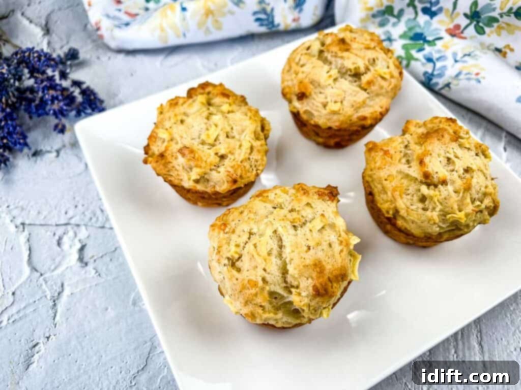 A fresh batch of Apple Cheddar Muffins cooling on a wire rack after baking, showcasing their golden crusts.