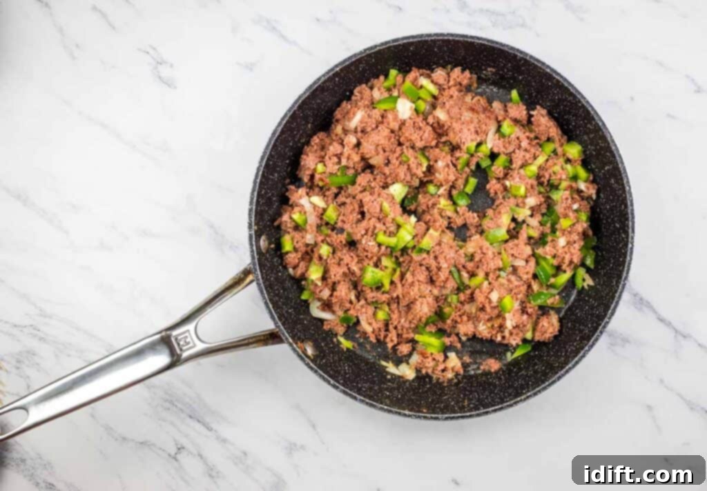 Hearty Corned Beef Hash Bake 9 Diced peppers and canned corned beef added to the skillet with sautéed onions.