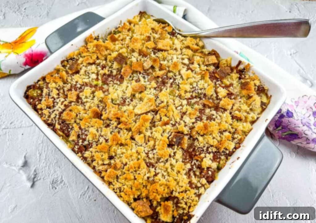 Hearty Corned Beef Hash Bake 5 A freshly baked Canned Corned Beef Hash Casserole resting in a baking dish with a serving spoon, emitting steam.